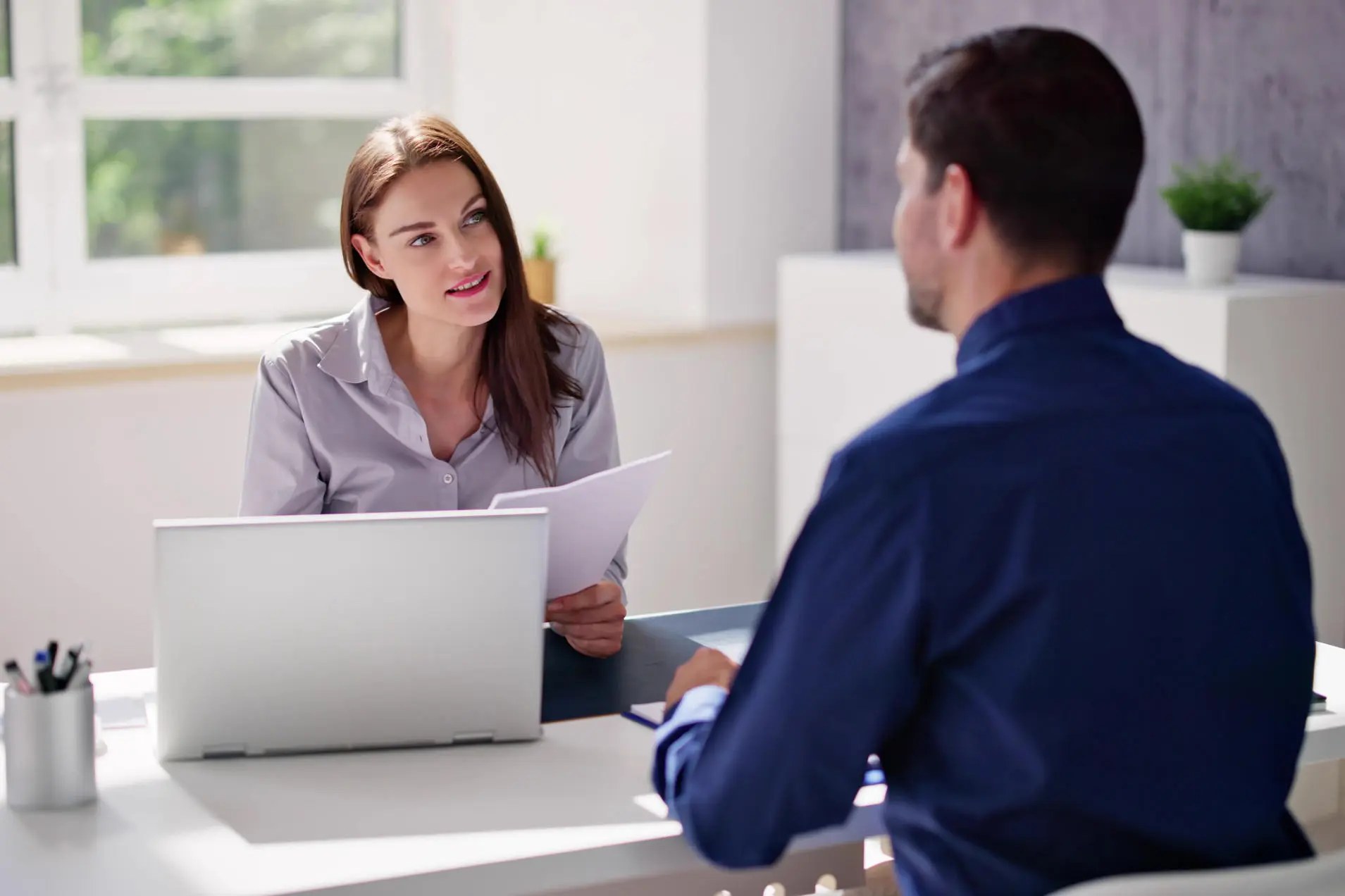 Business meeting between client and accounting company representative discussing tax and audit consulting services.