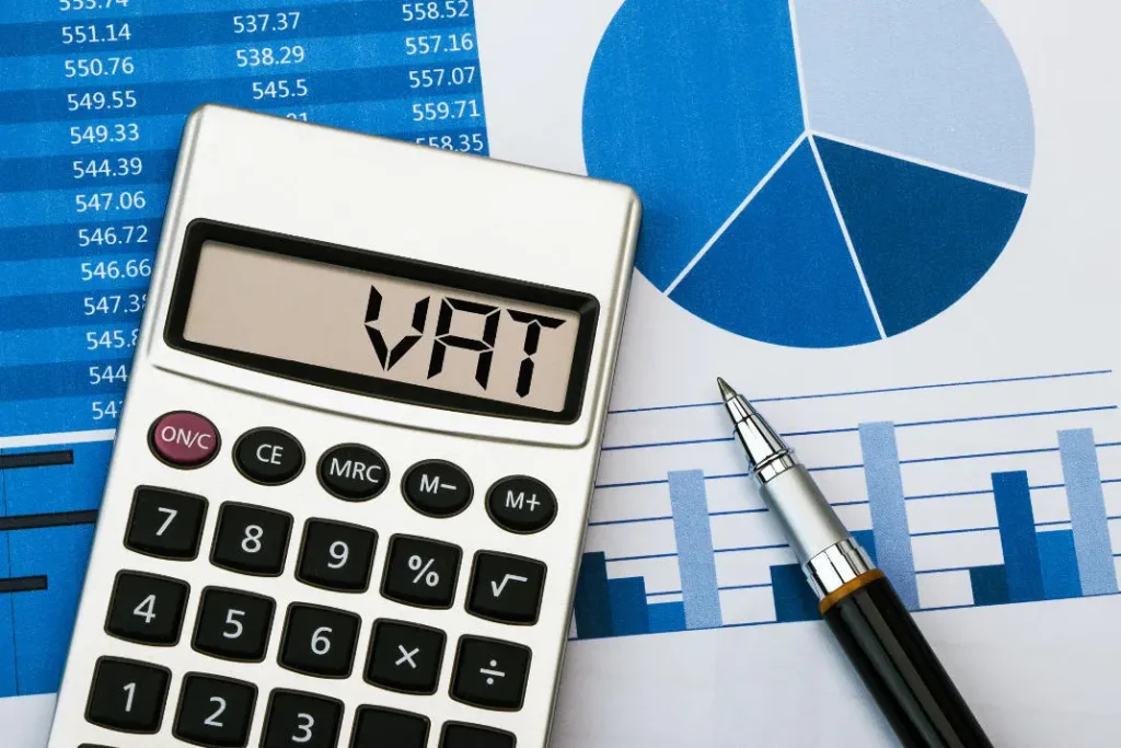 Calculator displaying VAT next to financial charts and graphs representing Thailand value added tax calculation